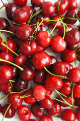 Raw red sweet cherry berries on white plate