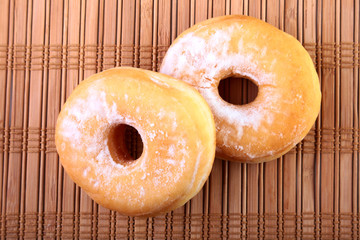 Homemade Doughnuts with Jelly filled and powdered sugar on Bamboo tablecloth. Selective focus.