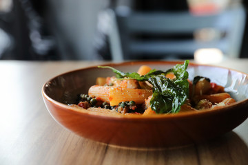 Pasta with sausage in tomato sauce on wood background , italian food
