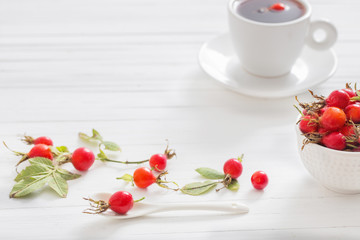 tea with berries of a dogrose on a wooden background