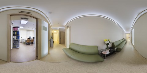 A cozy secluded corridor is a transition between the cabinets in the clinic with ice-back lighting on the ceiling and leather green sofas.