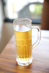 beer in tall glass on wood background