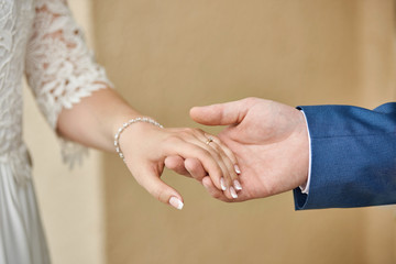 Wedding couple, Bride and groom holding hands, close-up. Romantic theme, expressing happiness, love, relationship, togetherness.