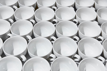 Top view on many stacked in rows of empty clean white cups for tea or coffee. Close-up. Background.