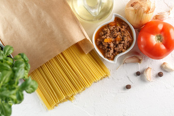 raw italian pasta spaghetti with vegetables on white background. Top view. Copyspace