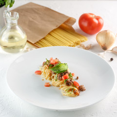 Delicious spaghetti with meat and tomato served on a white plate