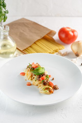 Delicious spaghetti with meat and tomato served on a white plate