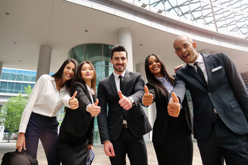 Portrait of business people of different ethnic backgrounds dressed in suits, they smile and cross...