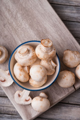Fresh champignons on a cutting board and in a bowl 