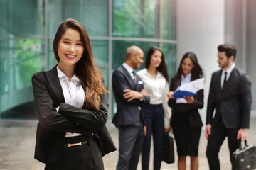 Portrait of business people of different ethnic backgrounds dressed in suits, they smile and cross...