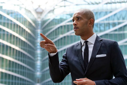 A business man looks at holographic and futuristic graphic on the performance of economic markets and banks. Concept of: success, future and tea