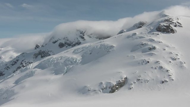 Clouds Moving Over Glaciated Peaks - Timelapse - Alaska - British Columbia - Winter - Sun - Snow - Mountains