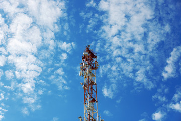 Cell tower on sky background with beautiful clouds