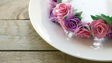 Obraz na płótnie Canvas Wedding table decoration: a wreath of flowers on a white plate