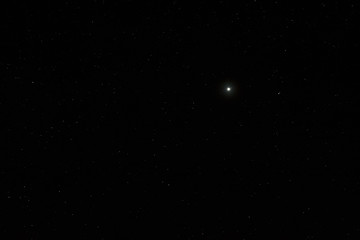 Night sky with a bright planet Jupiter. A view of the open space. Photographed close-up on long exposure.