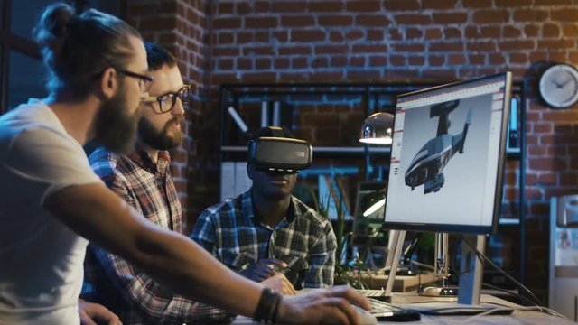Group of diverse men using VR technology and developing modern visual effects for videogame and computing