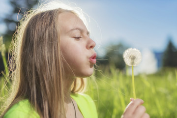 Girl blowing dandelion