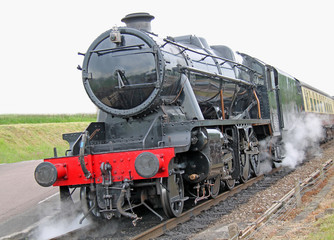 Fototapeta na wymiar A Powerful Steam Engine Pulling a Vintage Train.