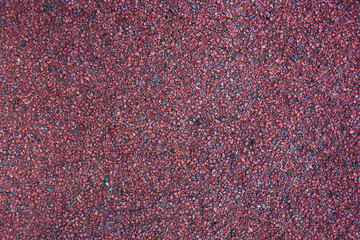 grainy red surface, background with small stones