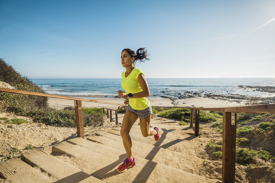 USA, California, Newport Beach, Woman running up stairs