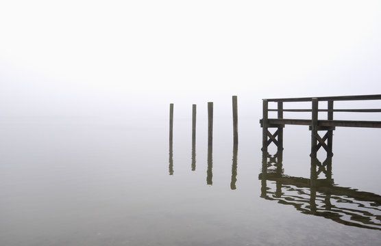USA, Massachusetts, Cape Cod, Eastham, Wooden posts and jetty in fog