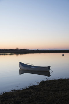 USA, Massachusetts, Cape Cod, Chatham, Boat reflecting in water at dawn