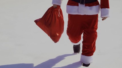 Santa Claus with bag of presents walk on the snow - Powered by Adobe
