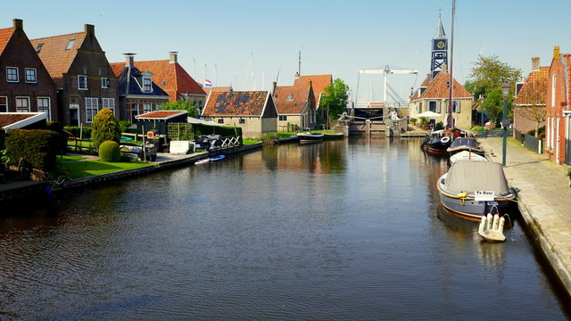 Blick vom Kanal zur alten Schleuse in Hindeloopen am Ijsselmeer mit vielen alten H&auml;usern
