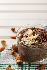 chia pudding with chocolate banana smoothie in a glass jar on the old wooden background