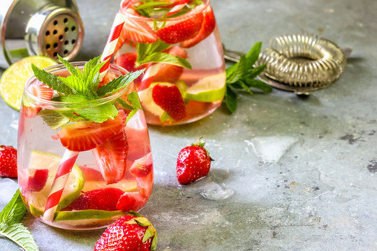 fresh lemonade with strawberries , lime and mint on a wooden background