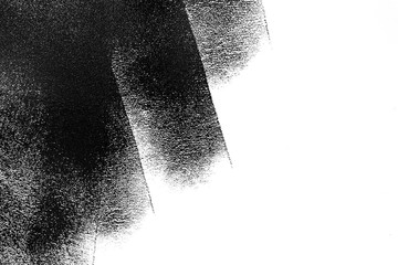 White wall partially painted in black with a paint roller