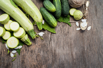 Raw zucchini and cucumbers with different seeds on  the wooden background. top view. Copy space