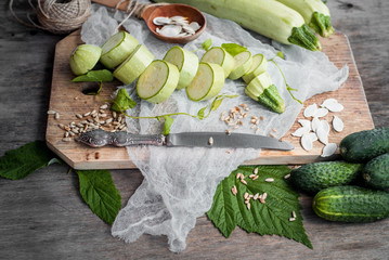 Raw сut zucchini and cucumbers with different seeds on  the wooden background. top view