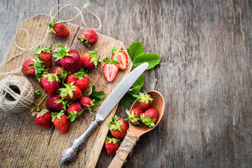 Sweet strawberries on the wooden background. Top view. Free space