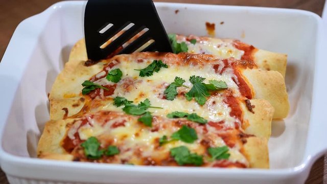 Traditional mexican enchiladas with chicken meat, spicy tomato sauce, corn, beans and cheese.