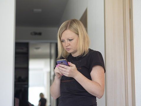 woman looking at the screen of the phone