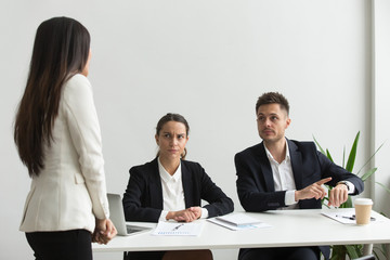 Angry executive pointing at wristwatch scolding unpunctual tardy employee for delay, missing...
