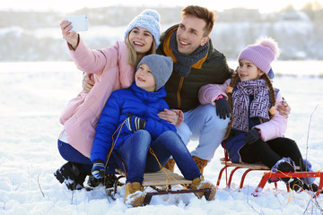 Fototapeta na wymiar Happy family taking selfie outdoors on winter day