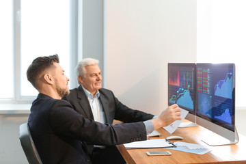 Male brokers working in office. Finance trading concept