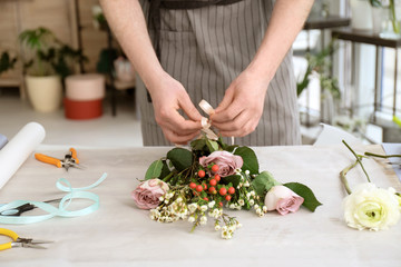 Obraz na płótnie Canvas Male florist creating bouquet at workplace