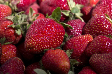Ripe red strawberry on the market, background. Useful berries from the garden, growing at home