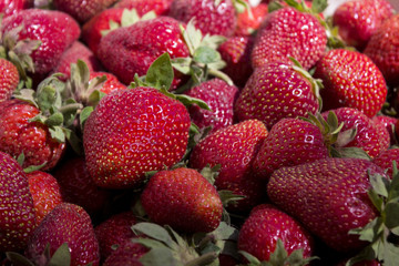 Ripe red strawberry on the market, background. Useful berries from the garden, growing at home