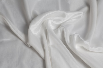 Closeup of rippled white silk fabric background