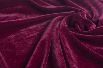 Fototapeta na wymiar Red velvet fabric with spiral folds