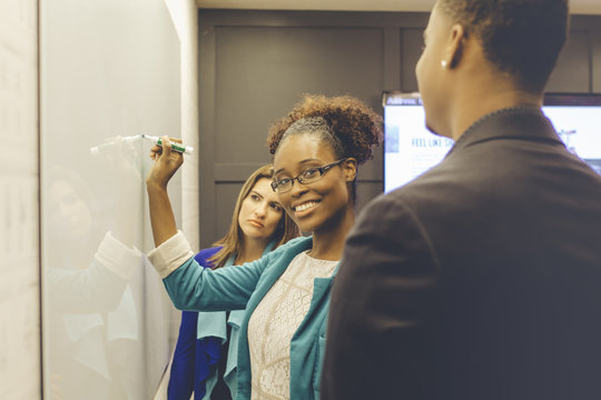 Smiling businesswoman writing on a whiteboard