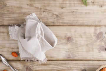 Gray textile napkin on a wooden table. place for text. Copy space. Flat lay.