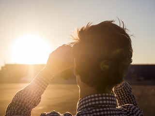 close up portrait of tourist looking through binoculars during sunset