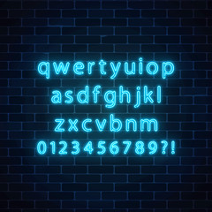 Fototapeta premium Vector neon style font. Glowing neon alphabet with lowercase letters on dark brick wall background.