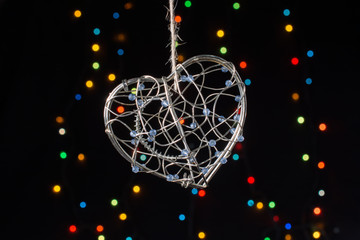Heart shaped metal cage on bokeh light background