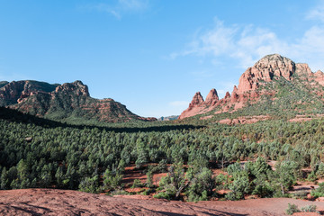 View of red rock formations and mountains in Sedona, Arizona.